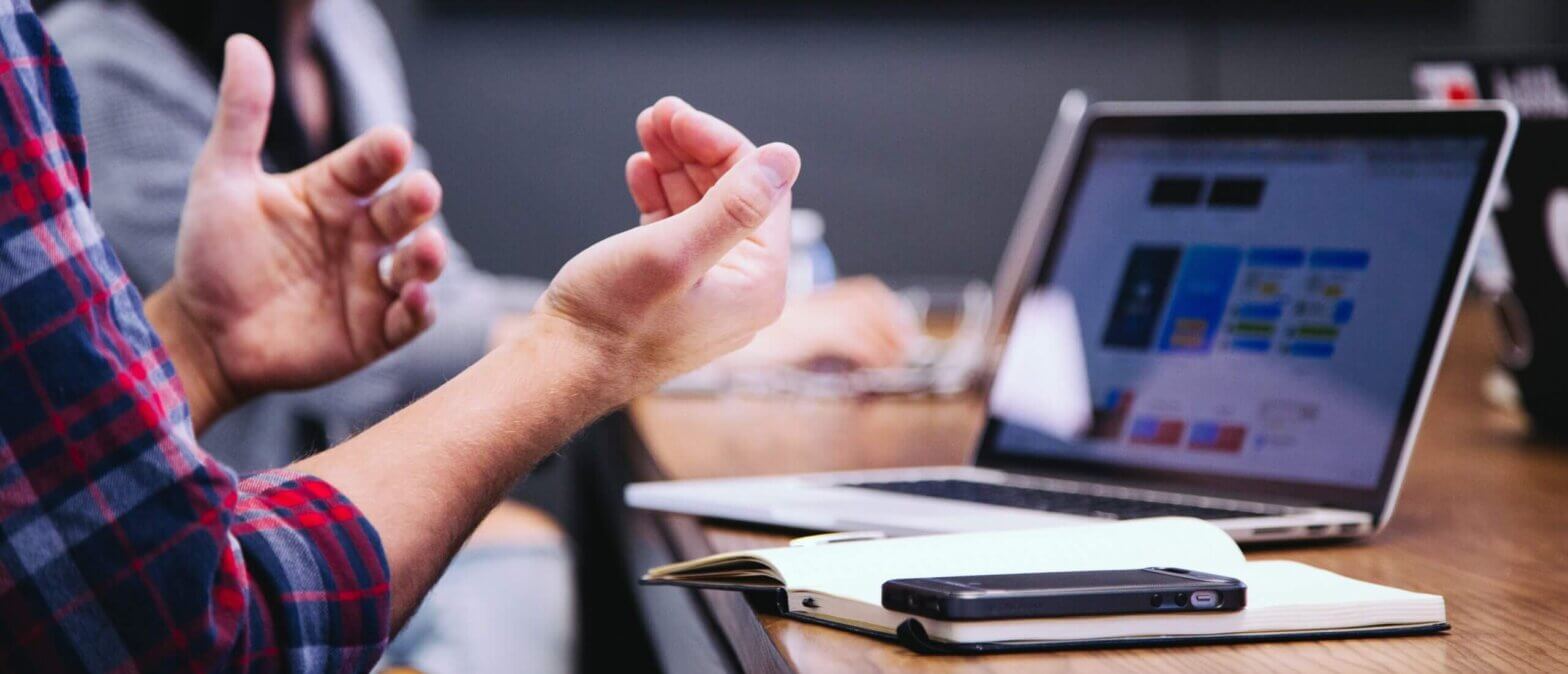 Image of employee talking with his hands during meeting