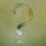 Question mark written on foggy glass