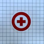 Red medical cross symbol on white tile