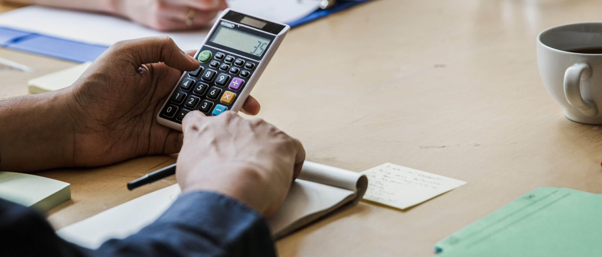 Employee calculating health plan affordability on calculator