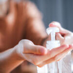 Employee using hand sanitizer