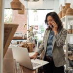 Small business owner a computer, on phone