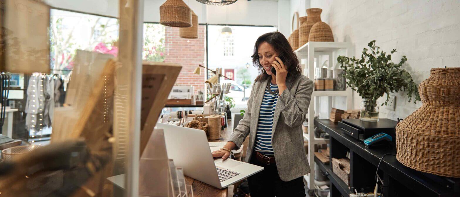 Small business owner a computer, on phone