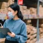 Masked woman taking inventory