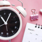 Image of a clock and a calendar with pink background
