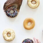 Diverse group of people grabbing donuts off a table