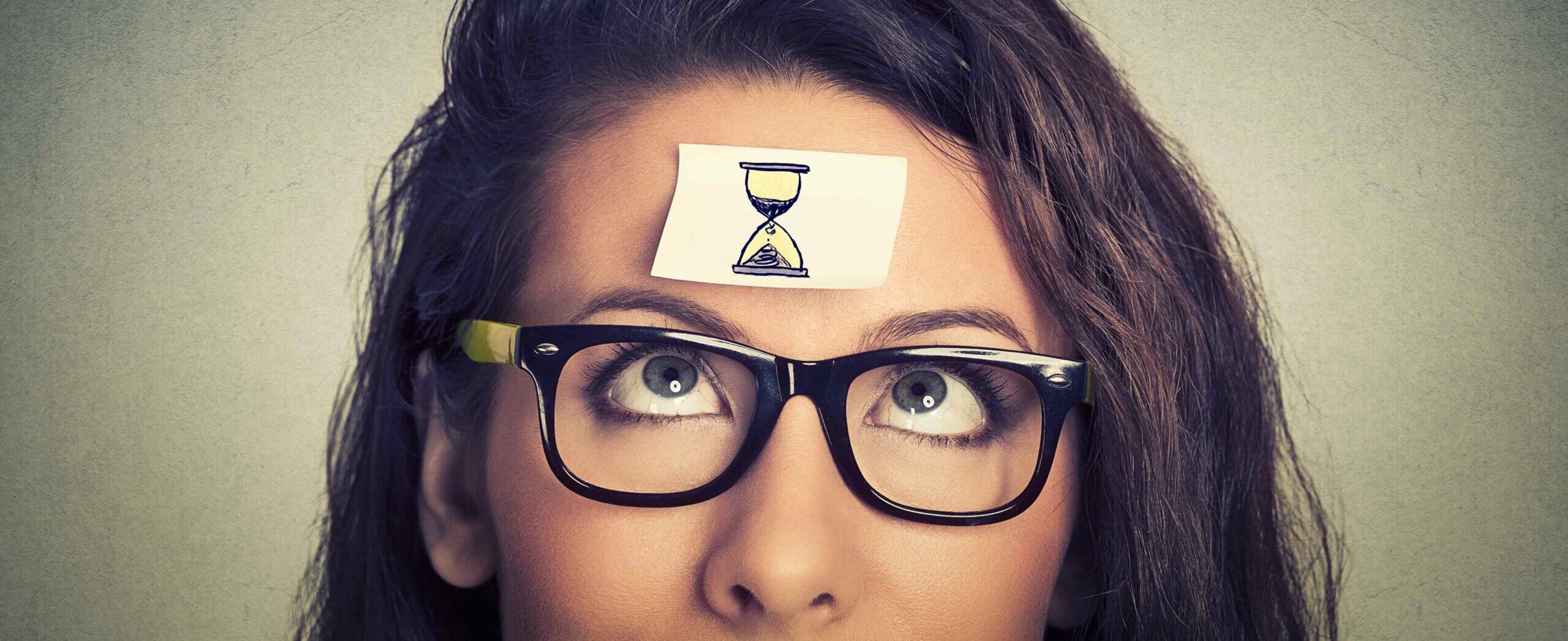 Woman looking at time sticker on her forehead