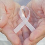 Hands holding pink cancer ribbon